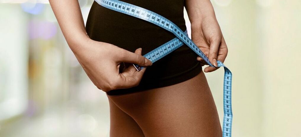 Una mujer nota los resultados de una pérdida de peso eficaz. 